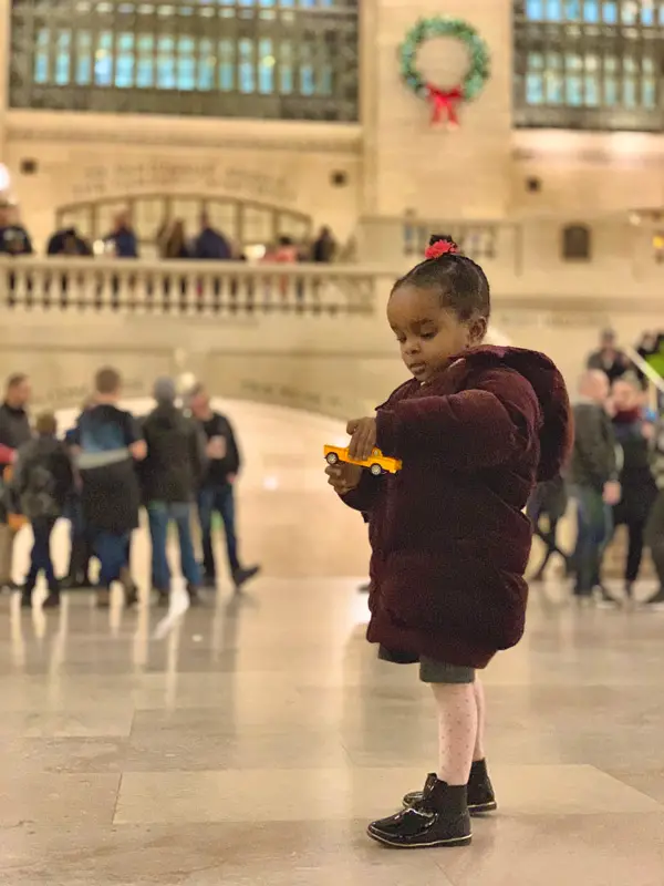 Little Toddler Girl Kid With NYC Yellow Taxi Toy in Grand Central Terminal Station
