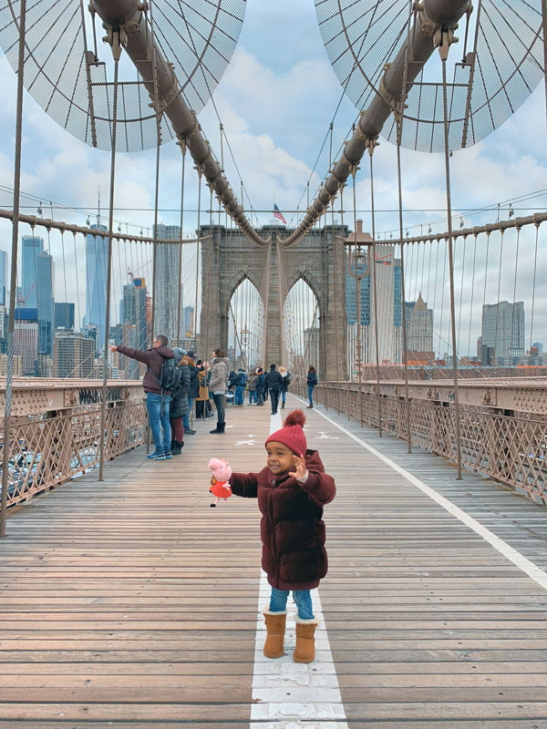 Little Toddler Girl Kid on Brooklyn Bridge, NYC with Peppa Pig Toy