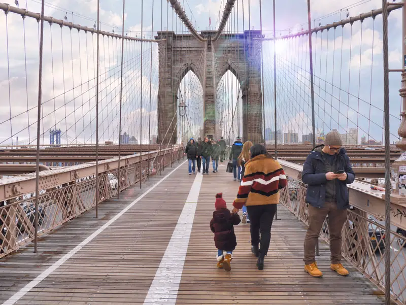 Mother and Daughter Walking Across Brooklyn Bridge NYC in the Winter