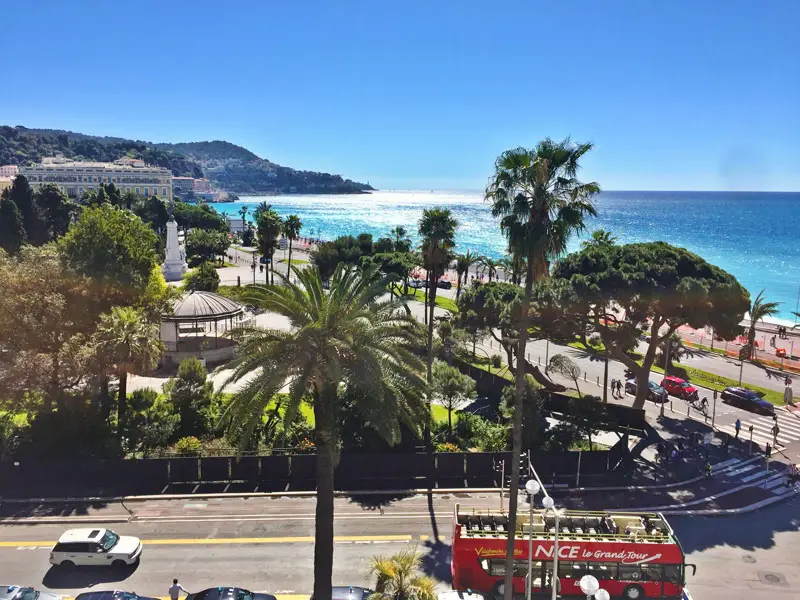 Nice France - Promenade des Anglais with Beach, Palm Trees and Red Bus