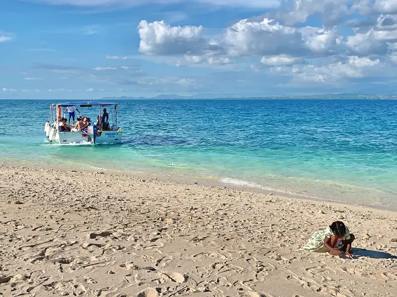 Little Girl on Beach While Boat Goes Snorkelling
