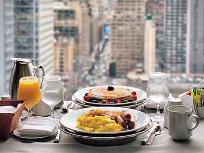 An American Breakfast: Pancakes, Eggs, Sausages and a City View
